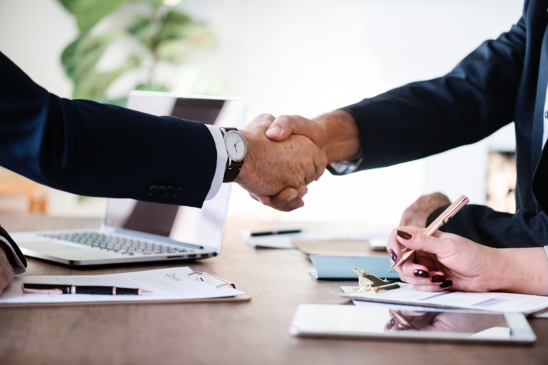 Two business people shaking hands over an agreement